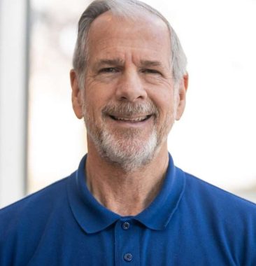 Dennis Foster Dennis Foster smiling in a blue polo shirt with "Vision Matters" embroidered, representing the Vision Matters team & mission.