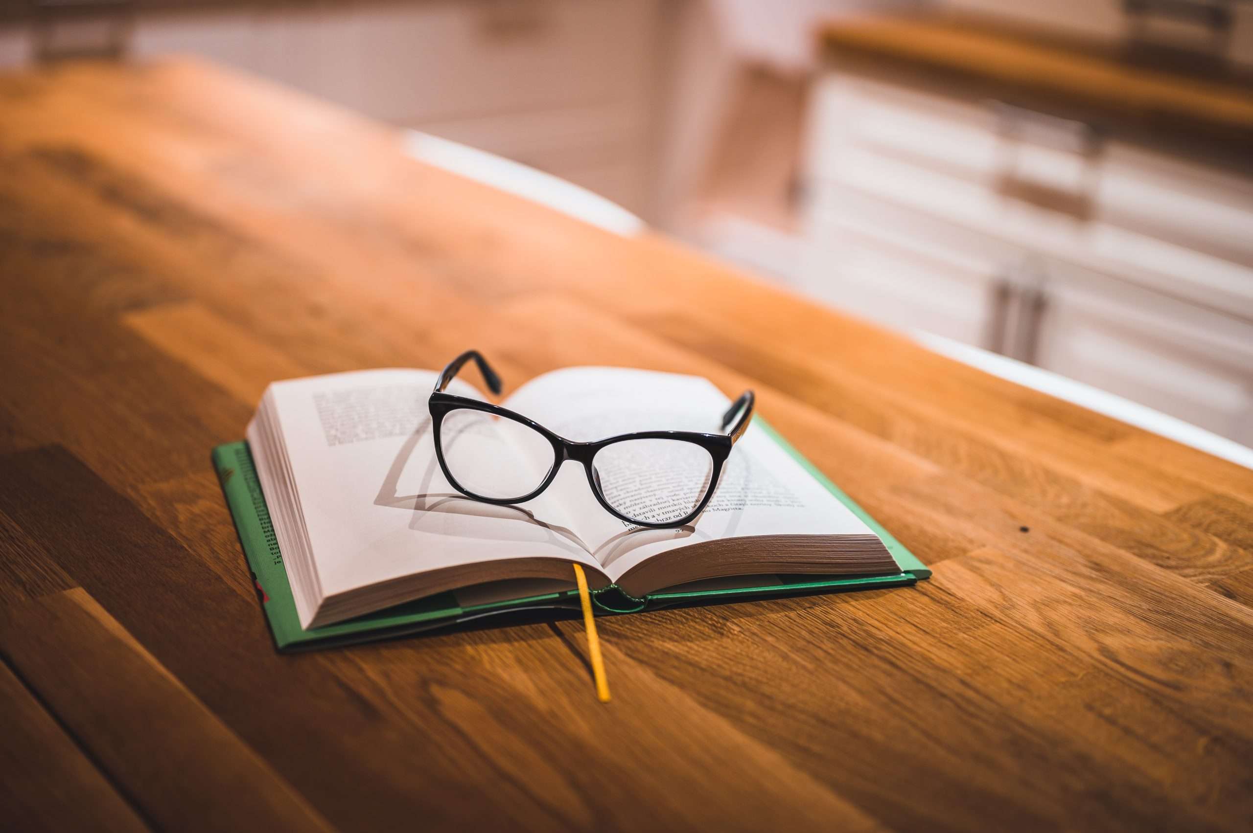 Open book and glasses on table. Book and glasses.